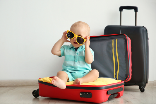 Baby sitting in suitcase with sunglasses on