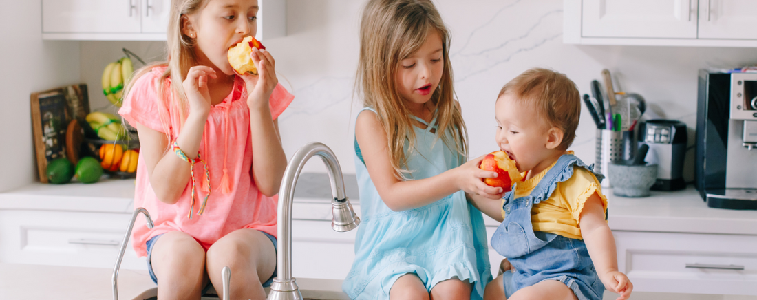 Three children eating apples