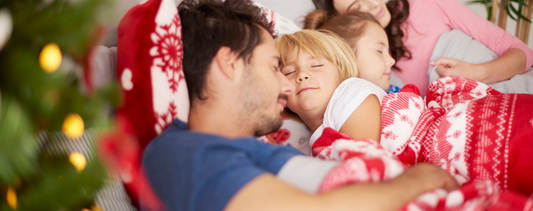 Family sleeping near Christmas tree